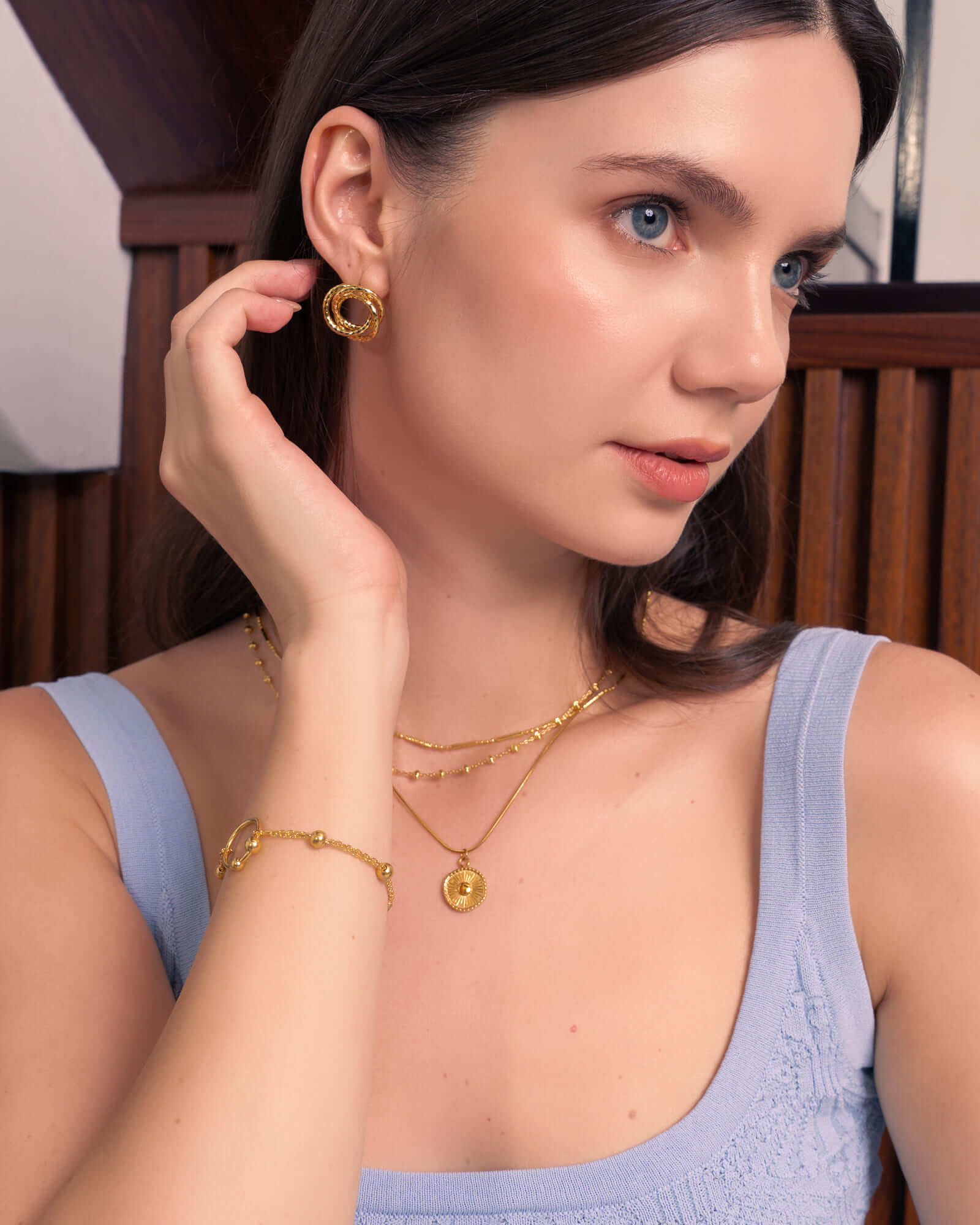Ray of Sun gold pendant necklace by Lavana, on model; engraved classic sunburst coin