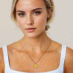 Ray of Sun gold pendant necklace by Lavana, on model; engraved sunburst coin