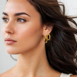 Rhythm Gold Hoop Earrings Medium and Large by Lavana on model wide polished hoop with light textured grooves layered