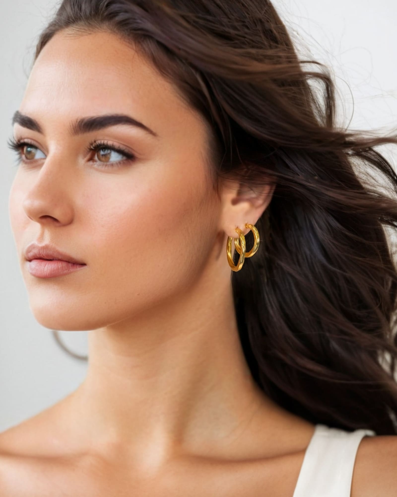 Rhythm Gold Hoop Earrings Medium and Large by Lavana on model wide polished hoop with light textured grooves layered
