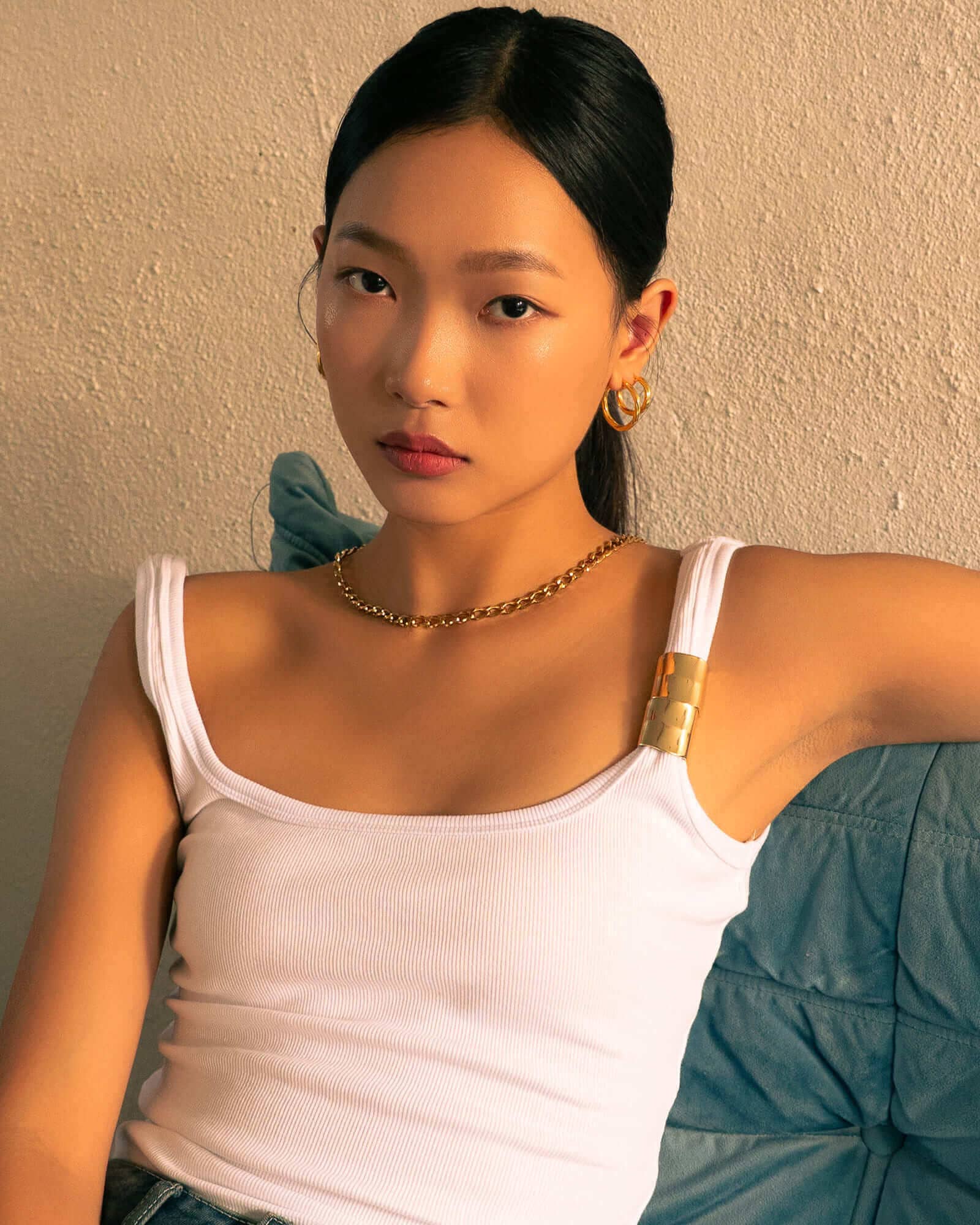 Rhythm Gold L Hoop Earrings by LAVANA, on model; wide polished dress hoops with light textured grooves