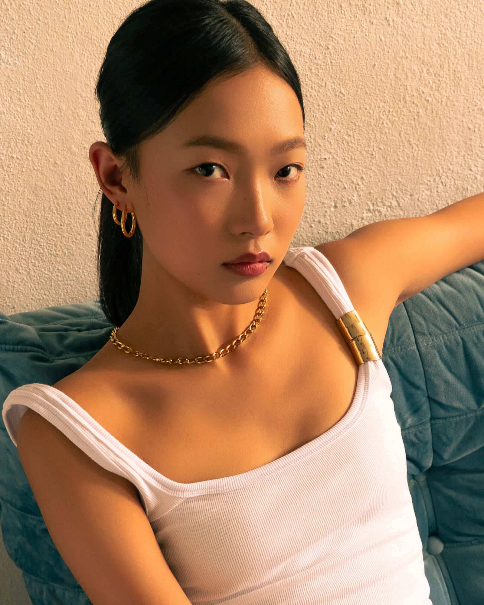 Rhythm Gold M Hoop Earrings by LAVANA, on model; wide polished dress hoops with light textured grooves