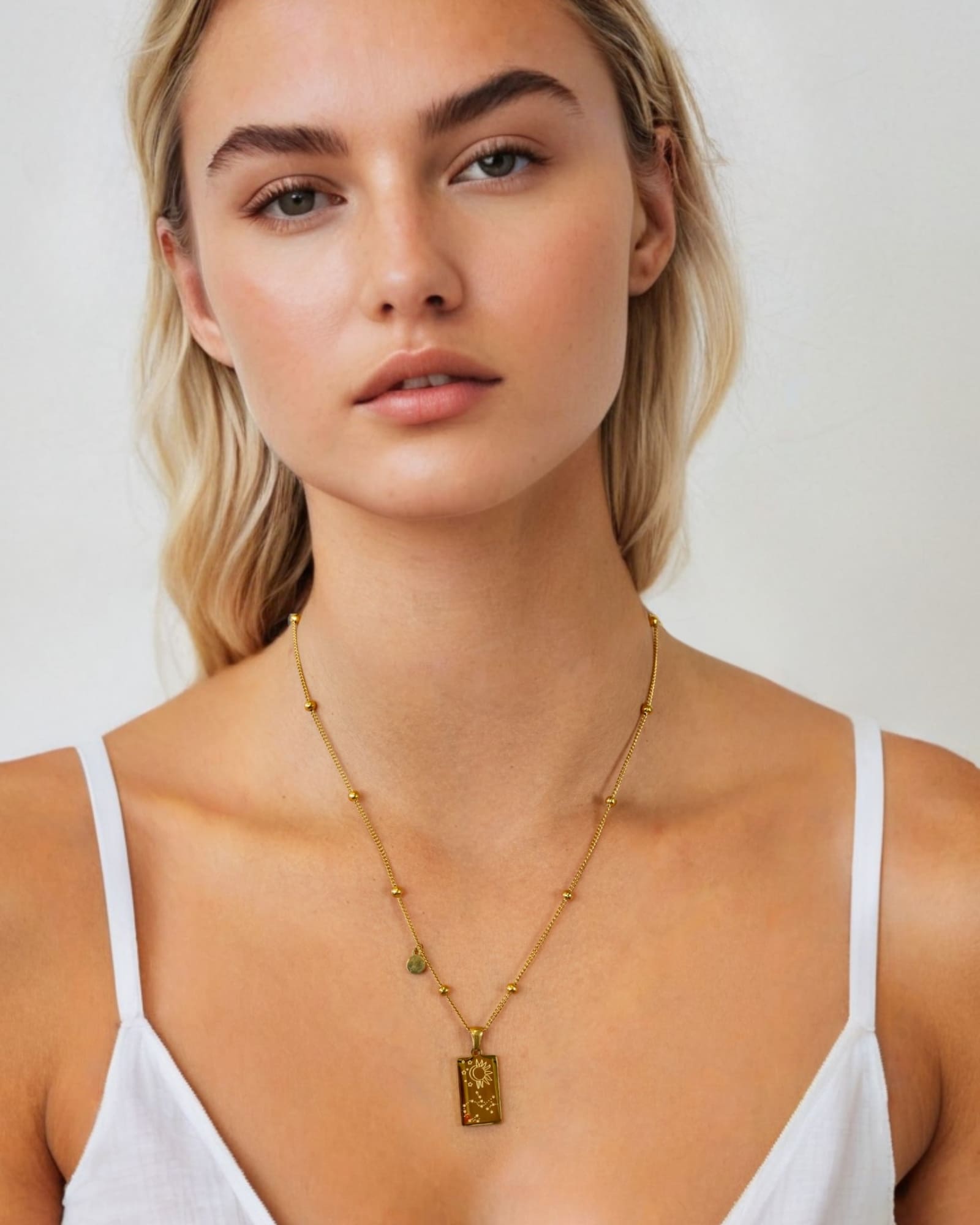 Sagittarius Gold Zodiac Tag Necklace by Lavana, on model; engraved tag on beaded chain, back