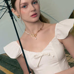 Sardinia gold pearl necklace by Lavana, on model; with classic asymmetric links and freshwater pearl drop