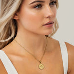 Starburst Coin Gold Necklace by Lavana, on model; coin pendant with engraved starburst compass
