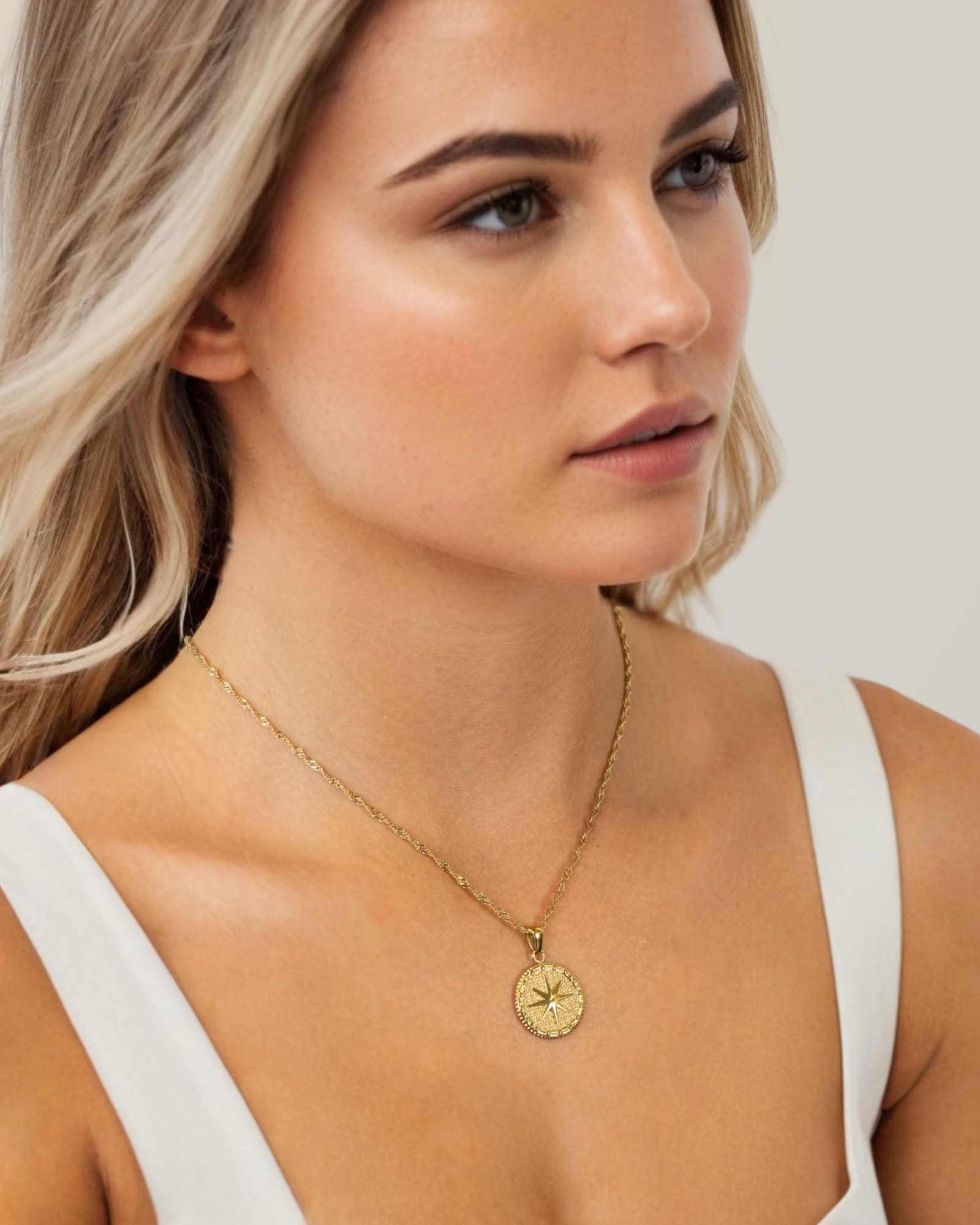 Starburst Coin Gold Necklace by Lavana, on model; coin pendant with engraved starburst compass