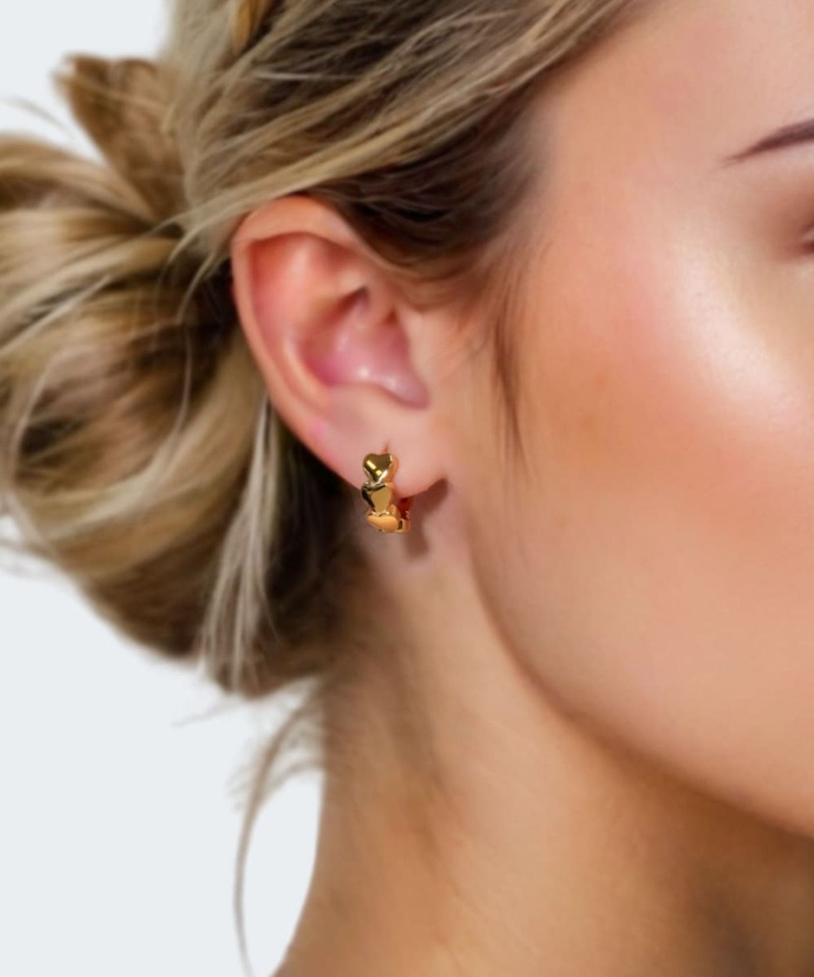 Sweetheart Gold Hoop Earrings by LAVANA on model four hearts stacked at the front