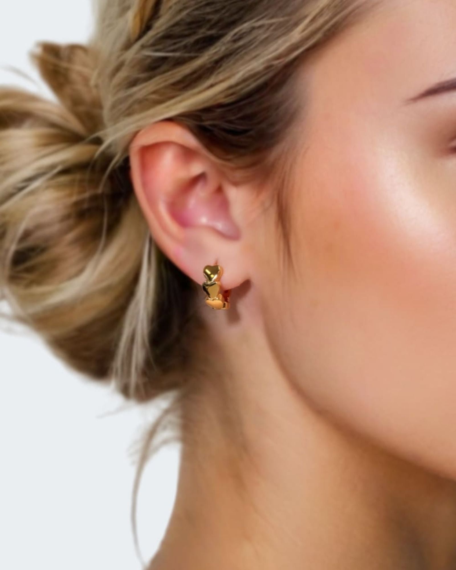 Sweetheart Gold Hoop Earrings by LAVANA on model four hearts stacked at the front