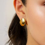 Swell Gold Stud Earrings by LAVANA on model with polished wave curve studs