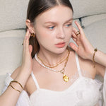 Swell Gold Stud Earrings by LAVANA,on model modern sculptural wave curve studs with high polish