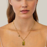 Taurus Gold Zodiac Tag Necklace by Lavana, on model; engraved tag with constellation on beaded chain, back