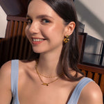 Twofold Heart Gold Stud Earrings by Lavana, on model; featuring a sleek textured double heart drop