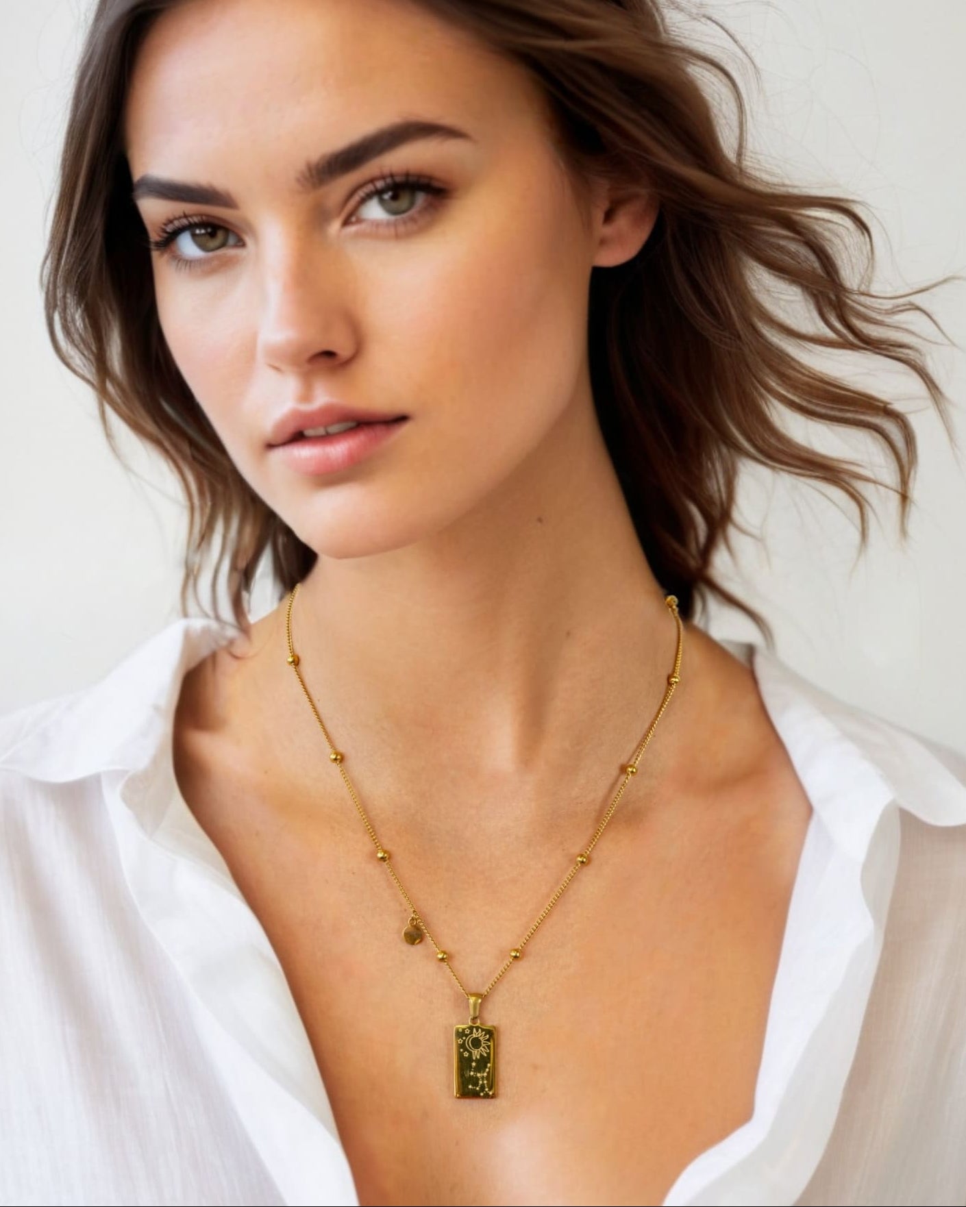 Virgo Gold Zodiac Tag Necklace by Lavana, on model; engraved tag front and back on beaded chain, back 